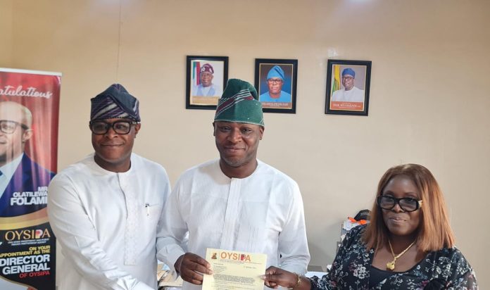 DG, OYSIPPA, Mr. Tilewa Folami, handing over the Mandate Letter of Grant to Engr. Yinka Owodunni. With them is the Permanent Secretary, Ministry of Lands, Mrs. Modupe Adebiyi.