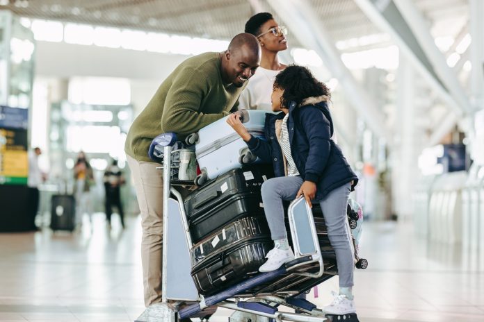 African,Family,With,Luggage,Trolley,Waiting,At,Airport,Terminal,For